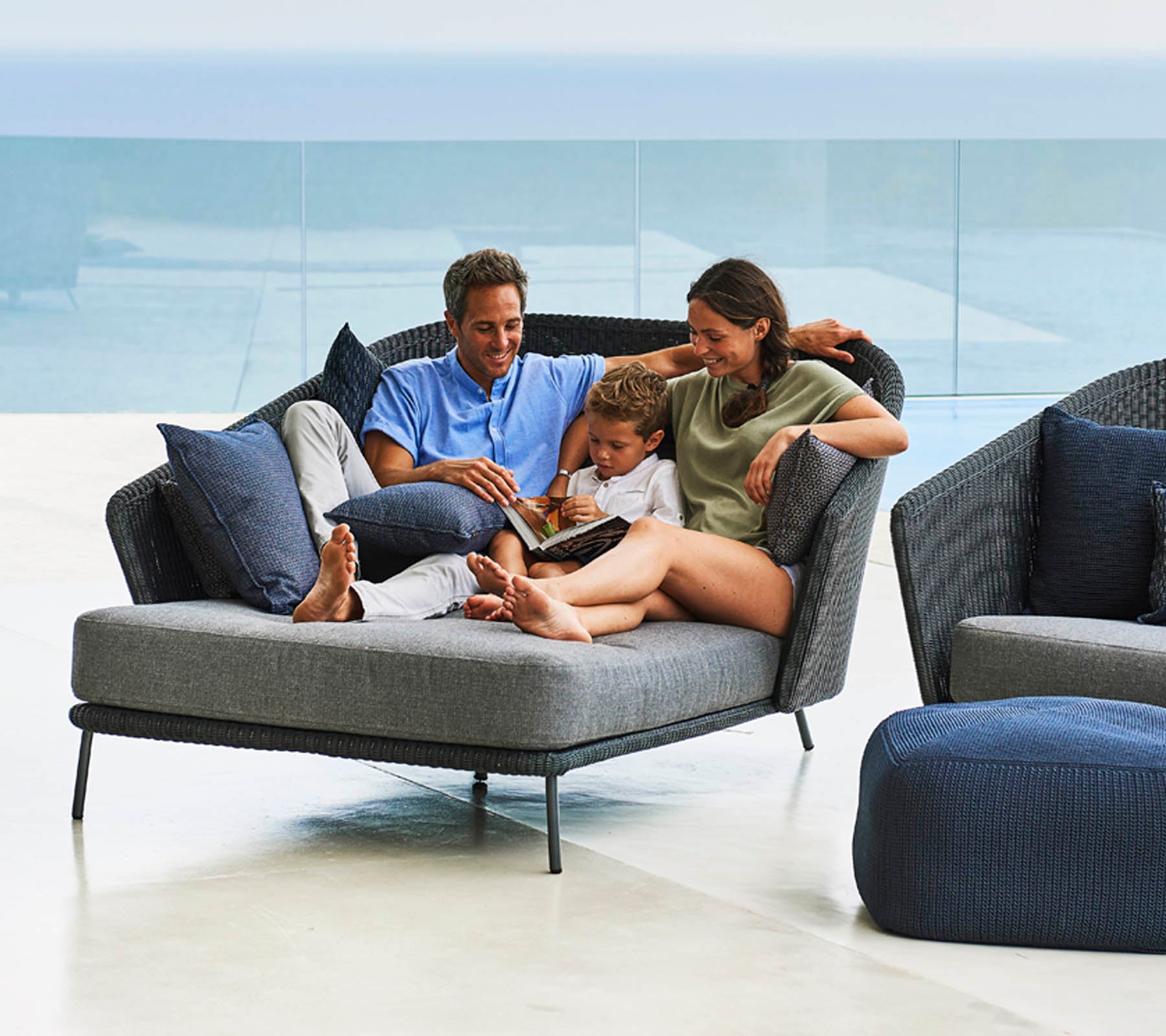 Family enjoying quality time together, reading a book on a stylish, comfortable lounge chair with soft cushions.