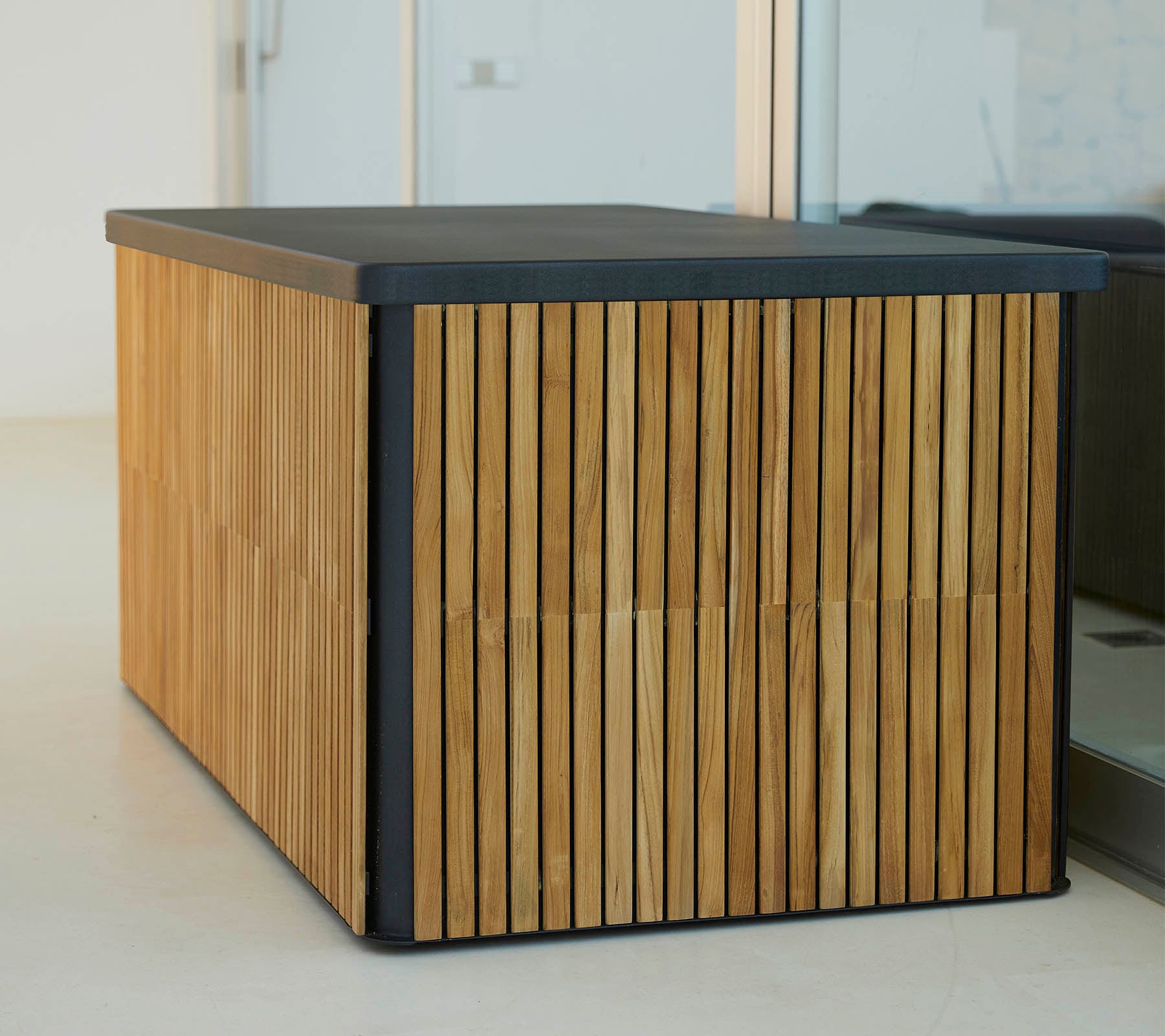 A modern wooden table with vertical slats on the sides and a sleek dark top, offering a stylish and functional design.