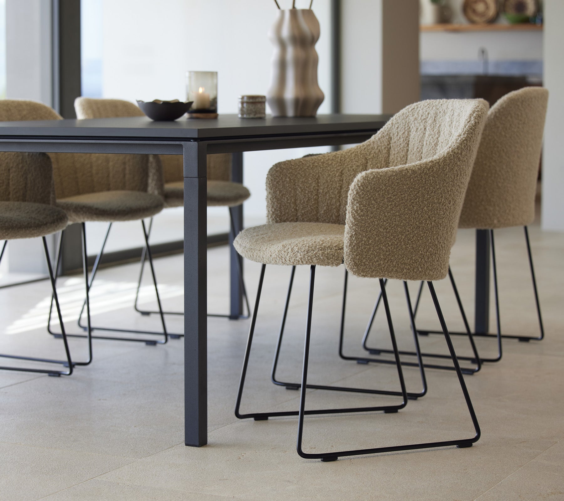 A stylish dining table with textured chairs, featuring a modern design and minimalist elements, set for an inviting dining experience.